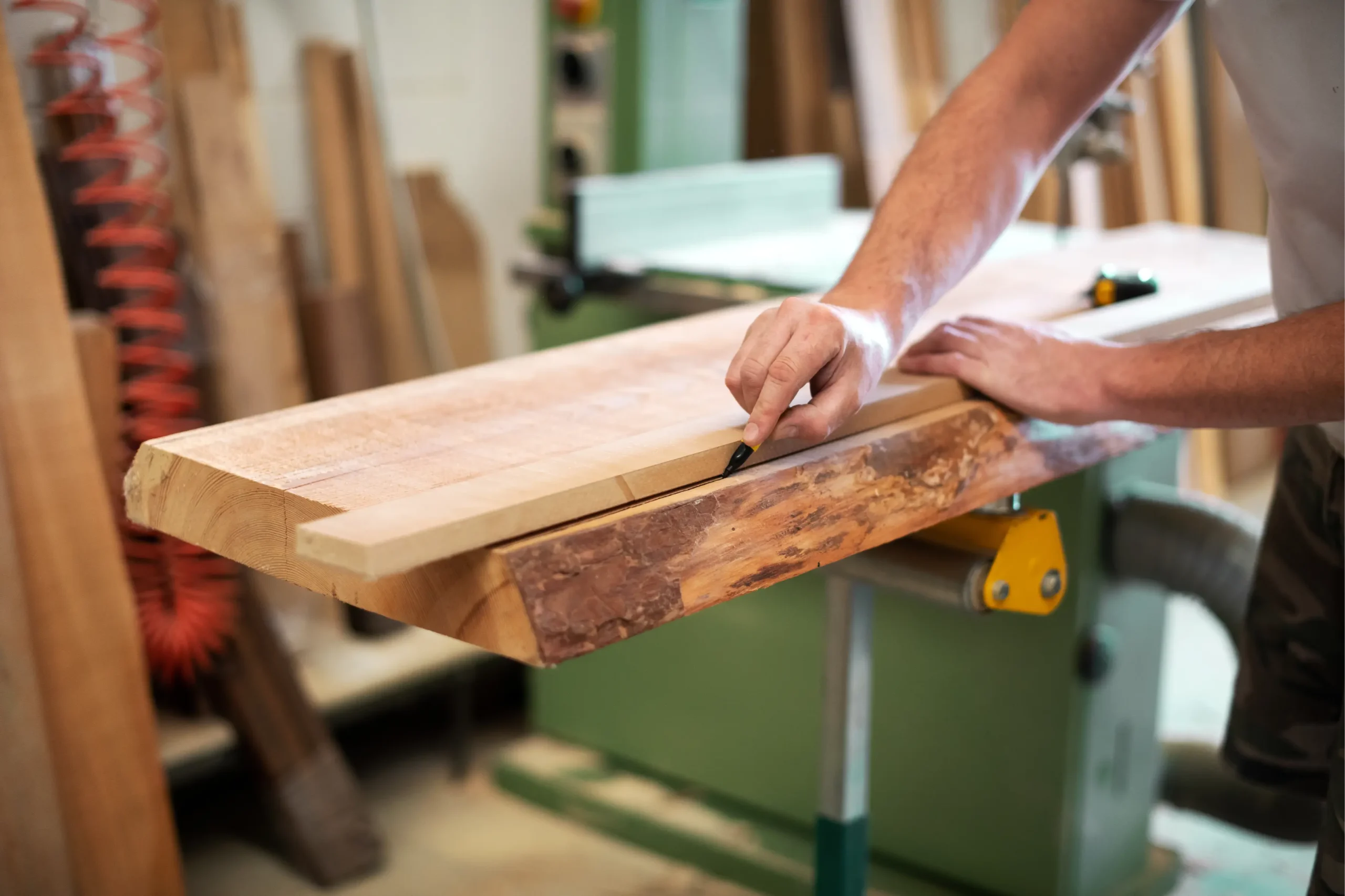 "Carpenter measuring raw wood slab with measuring tool in woodworking workshop"