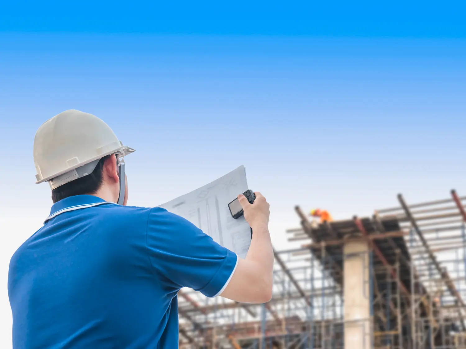 construction-site-engineer-inspecting-building-progress-with-blueprints-wearing-safety-helmet